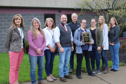 CH2M HILL BWXT West Valley (CHBWV) team holds a plaque commending the company for contributing $8.3 million toward a milestone $2 billion in savings by the U.S. Department of Energy’s Supply Chain Management Center. 