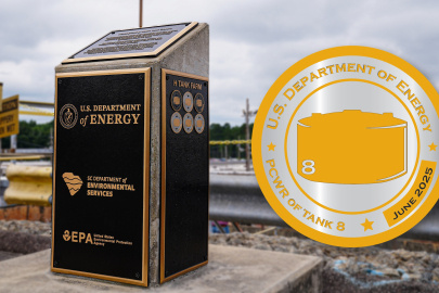 An outside marker with plaques on it, with a yellow and silver logo beside it