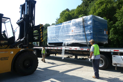 A large package on the back of a truck being lifted by a forklifted