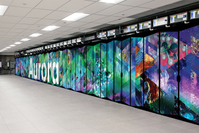 An image of the Aurora supercomputer cabinet, which has its name on it and a variety of abstract scientific symbols and patterns