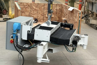 A white, black and grey piece of robotic machinery