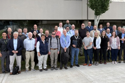 A large group of people posing for a group picture outside of a building