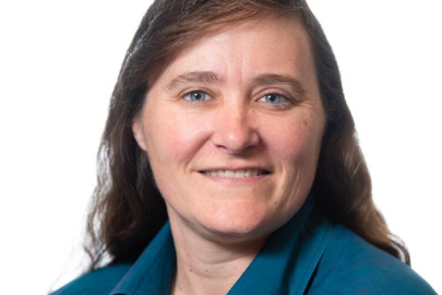 Professional headshot of a woman with brown hair wearing a blue shirt