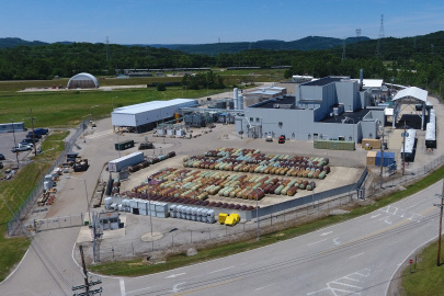 Aerial view of a large facility building with lots of canisters lined up outside of the building