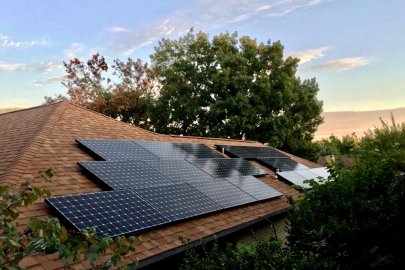 sun sets over a rooftop solar installation