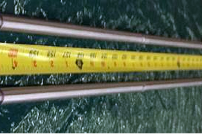 A photo of a nuclear test rod with measuring tape by it