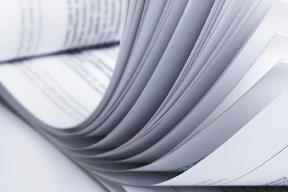 Black and white photo of pages in a book being flipped through. 