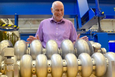 Andrew Hutton, associate director of Jefferson Lab’s Accelerator Division, looks over prototype particle accelerating devices – called cavities – in the lab’s Superconducting Radiofrequency Institute.