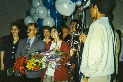 Candice Kamachi (in red coat) and her teammates were greeted as they arrived home in California after winning the 1996 National Science Bowl® in Washington, D.C.