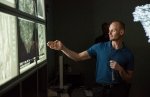 Photo of a man pointing to images of catalytic fast pyrosis