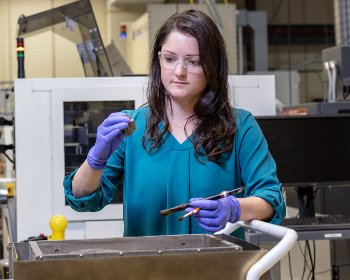 Amy Elliott, a robotics and automation researcher at ORNL, uses binder 3D printing, a technique that can produce objects in shapes and out of materials that are typically difficult to print by fusing together layers of metal powder spread across a surface.