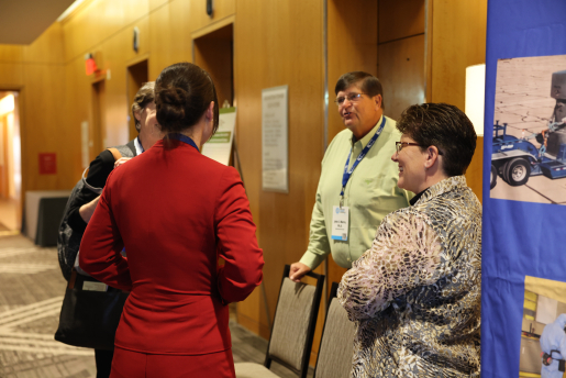 Four people standing by a conference booth.