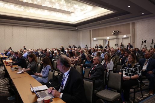 People sitting in chairs in a hotel ballroom