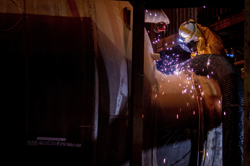 Workers use a torch to cut process gas equipment free from the uranium enrichment cascade.