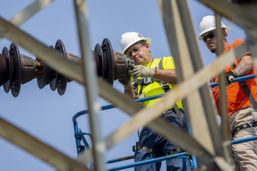 Photo of two workers with helmets on.