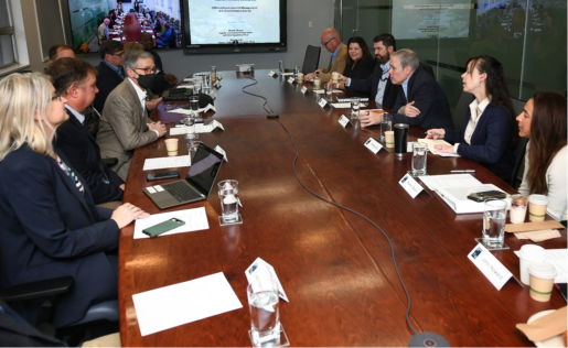 A group of people sitting at a large conference table having a meeting.