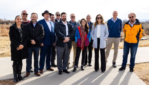 A group of people standing outside posing for a group photo.