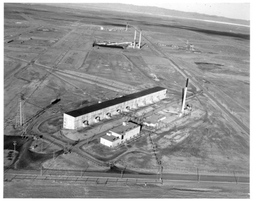 Aerial view of a factory building in the middle of a field