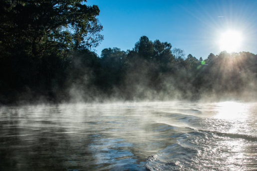 Photo of a river with the sun setting.