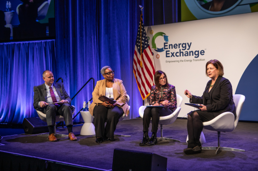 People participating in a panel discussion on a conference stage.