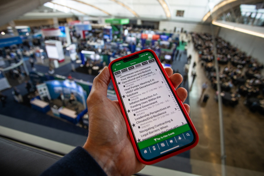 A smartphone with the conference's app on screen.