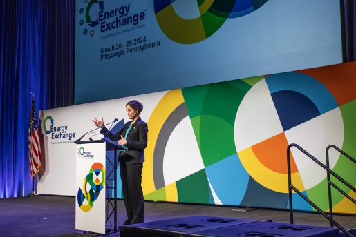 A person speaking at a podium on the main stage at the conference.
