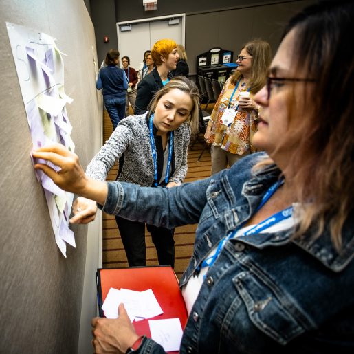 People posting sticky notes to a board.