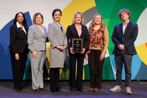 A group of individuals at an awards ceremony smiling at the camera.