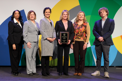 A group of individuals at an awards ceremony smiling at the camera.