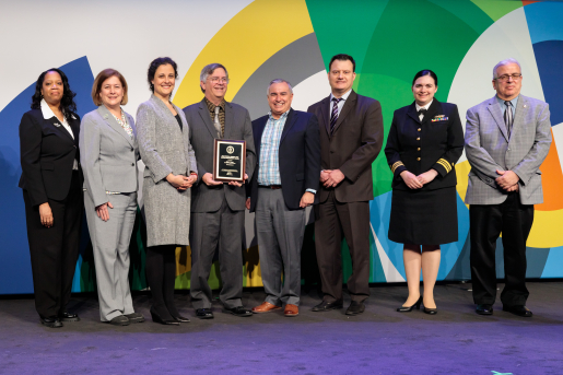 A group of individuals at an awards ceremony smiling at the camera.