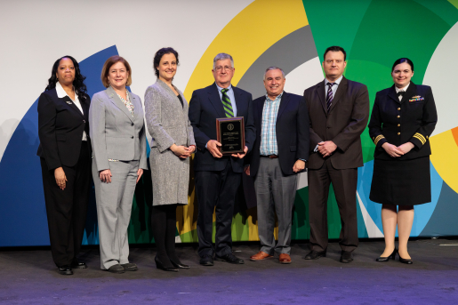 A group of individuals at an awards ceremony smiling at the camera.