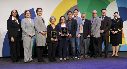 A group of individuals at an awards ceremony smiling at the camera.