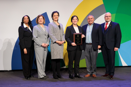 A group of individuals at an awards ceremony smiling at the camera.