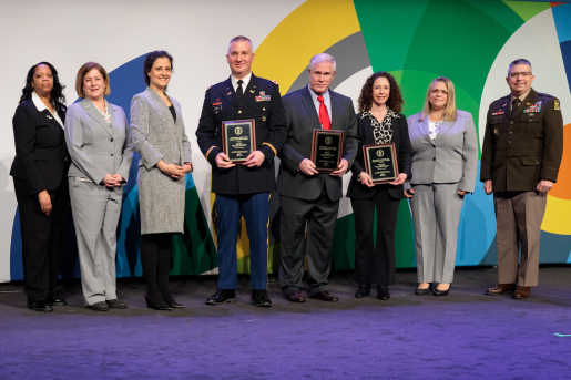 A group of individuals at an awards ceremony smiling at the camera.