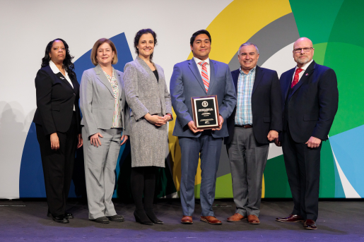 A group of individuals at an awards ceremony smiling at the camera.