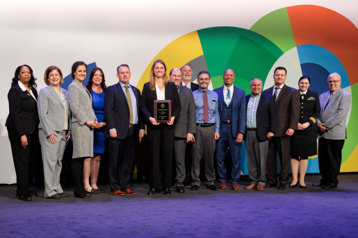 A group of individuals at an awards ceremony smiling at the camera.