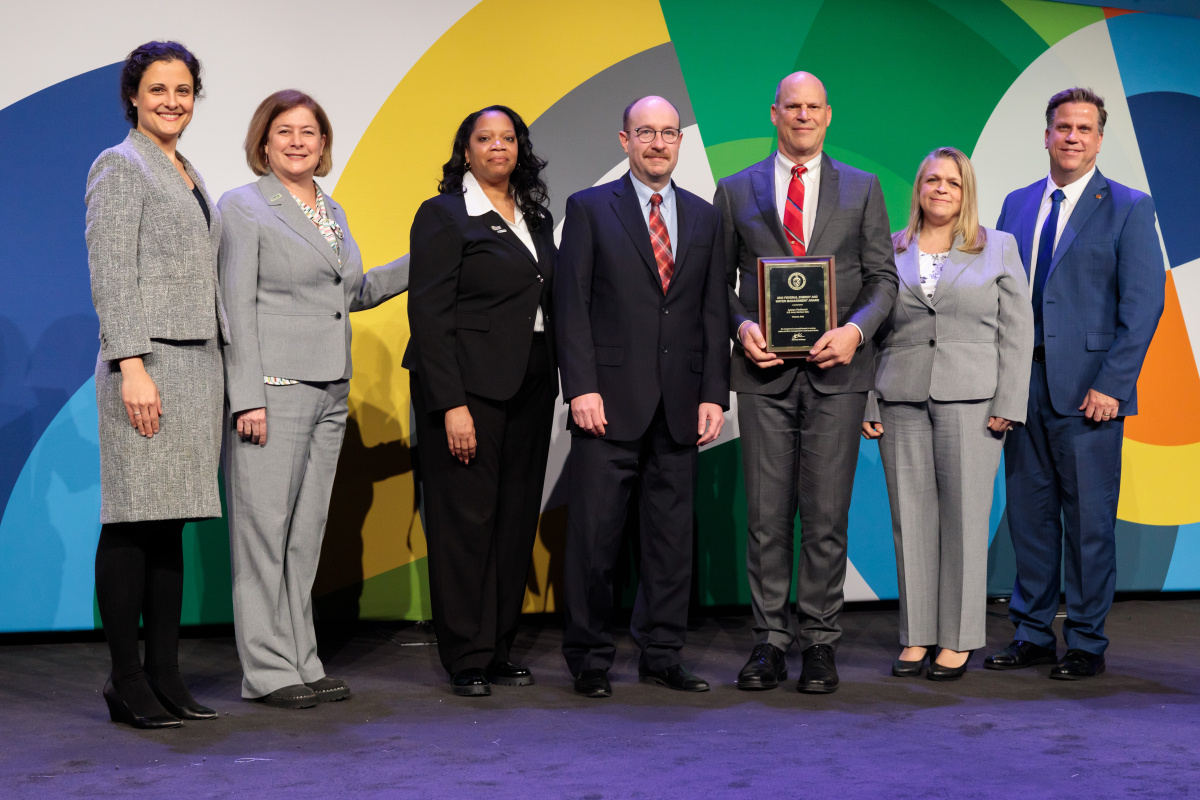 A group of individuals at an awards ceremony smiling at the camera.