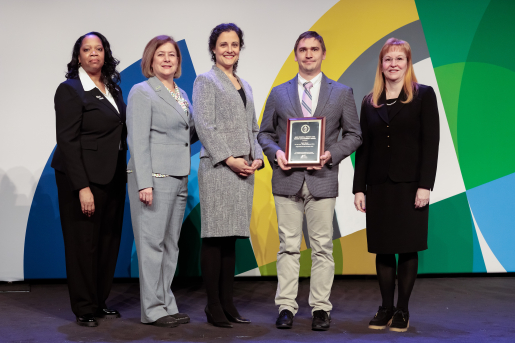 A group of individuals at an awards ceremony smiling at the camera.