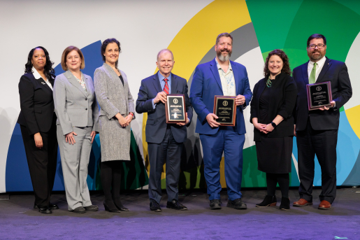 A group of individuals at an awards ceremony smiling at the camera.