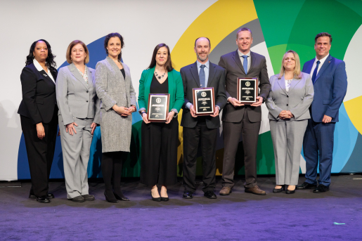 A group of individuals at an awards ceremony smiling at the camera.