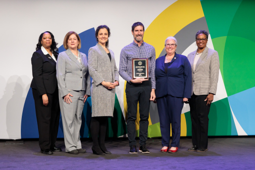 A group of individuals at an awards ceremony smiling at the camera.