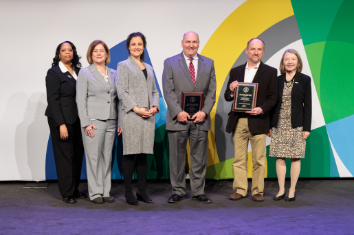 A group of individuals at an awards ceremony smiling at the camera.