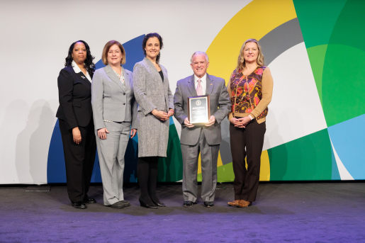 A group of individuals at an awards ceremony smiling at the camera.