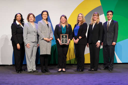 A group of individuals at an awards ceremony smiling at the camera.