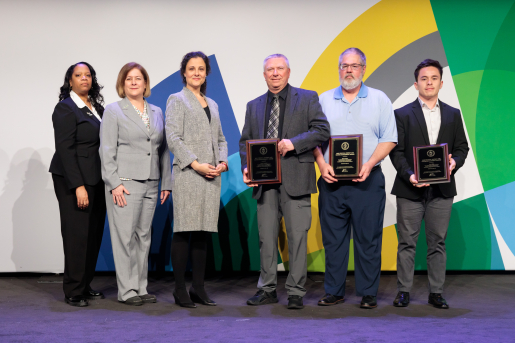 A group of individuals at an awards ceremony smiling at the camera.