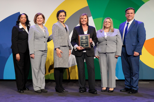 A group of individuals at an awards ceremony smiling at the camera.