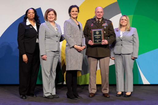 A group of individuals at an awards ceremony smiling at the camera.