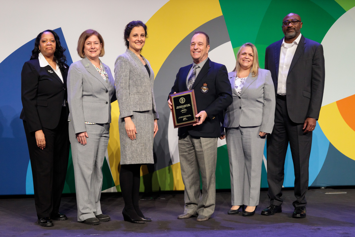 A group of individuals at an awards ceremony smiling at the camera.