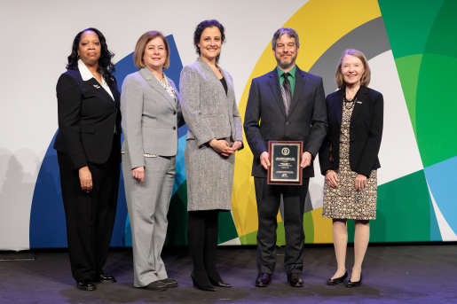 A group of individuals at an awards ceremony smiling at the camera.