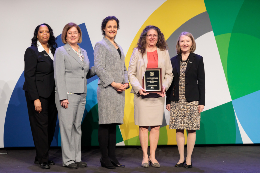 A group of individuals at an awards ceremony smiling at the camera.